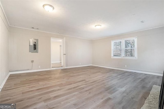 spare room featuring hardwood / wood-style floors and electric panel