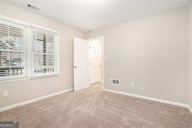 unfurnished room with light colored carpet