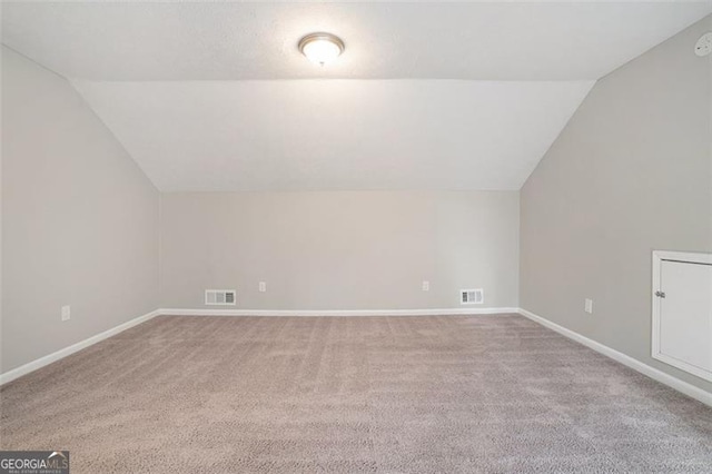 bonus room with light carpet and lofted ceiling