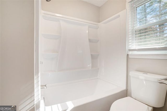 bathroom featuring shower / bath combination, toilet, and plenty of natural light