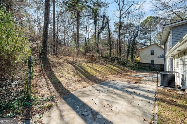 view of yard with central air condition unit and a patio