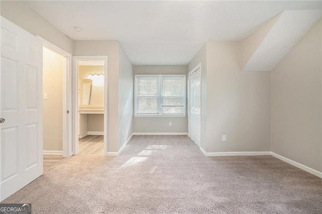 unfurnished bedroom with light carpet and ensuite bathroom