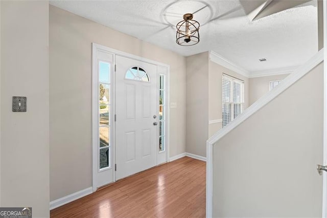 entrance foyer featuring hardwood / wood-style floors, a textured ceiling, and an inviting chandelier