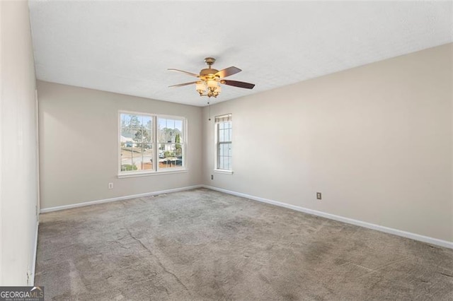 spare room with ceiling fan and light carpet