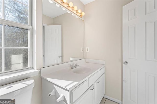 bathroom featuring tile patterned floors, vanity, toilet, and a wealth of natural light