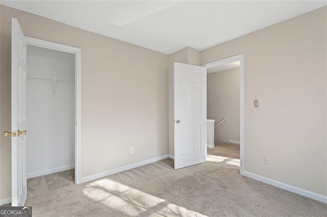 unfurnished bedroom featuring light colored carpet and a closet