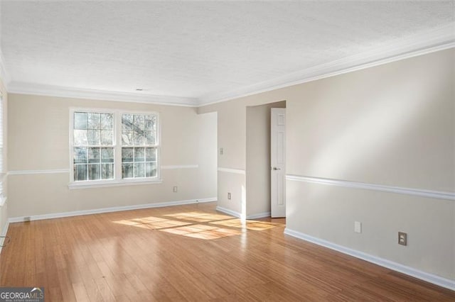 spare room with light wood-type flooring and crown molding