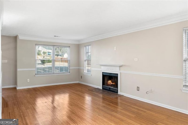 unfurnished living room with hardwood / wood-style flooring and crown molding