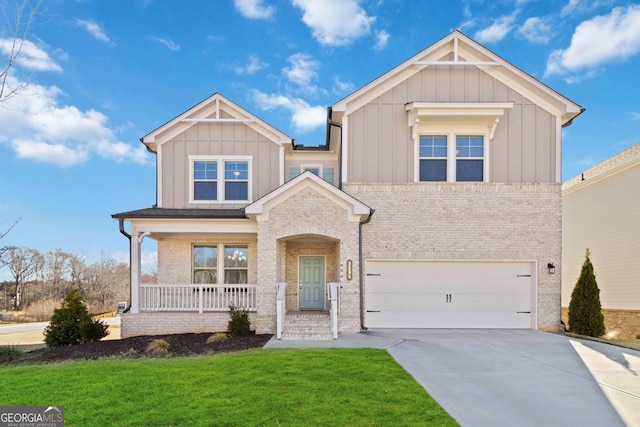 view of front of house featuring covered porch, a garage, and a front lawn