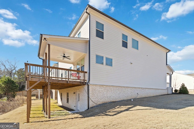 rear view of house with ceiling fan, a yard, and a deck