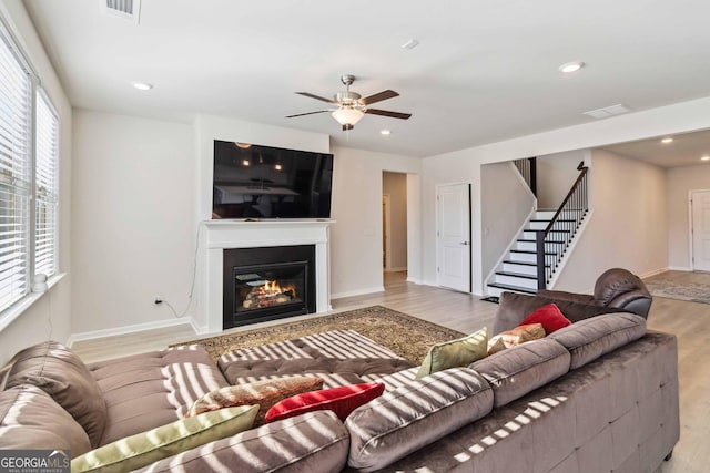 living room with light hardwood / wood-style flooring, plenty of natural light, and ceiling fan