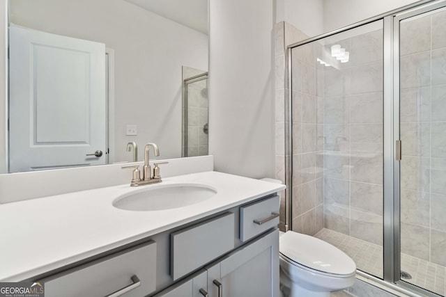 bathroom with vanity, toilet, and a shower with shower door