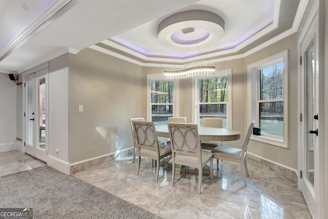 dining area featuring a tray ceiling, crown molding, and a notable chandelier