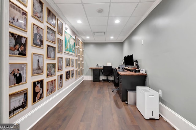 office area with a paneled ceiling and dark hardwood / wood-style floors