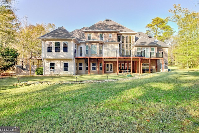 rear view of house with a wooden deck, a yard, and a patio