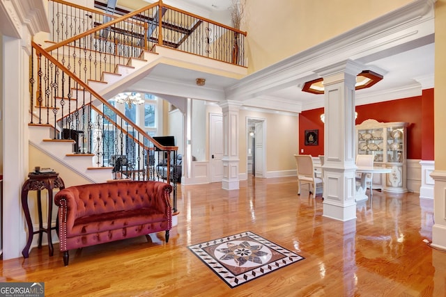 entrance foyer with hardwood / wood-style floors, crown molding, and an inviting chandelier