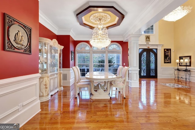 dining area with french doors, a notable chandelier, crown molding, and wood-type flooring