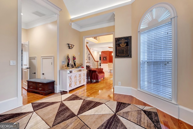 entrance foyer featuring crown molding and light hardwood / wood-style flooring