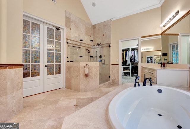 bathroom featuring tile patterned flooring, a shower with shower door, vanity, and high vaulted ceiling