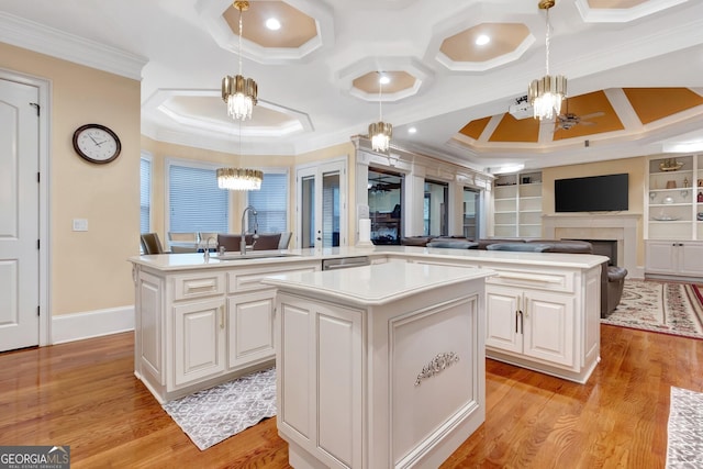 kitchen with a kitchen island, decorative light fixtures, built in shelves, sink, and kitchen peninsula