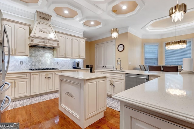 kitchen with premium range hood, stainless steel appliances, sink, and decorative light fixtures