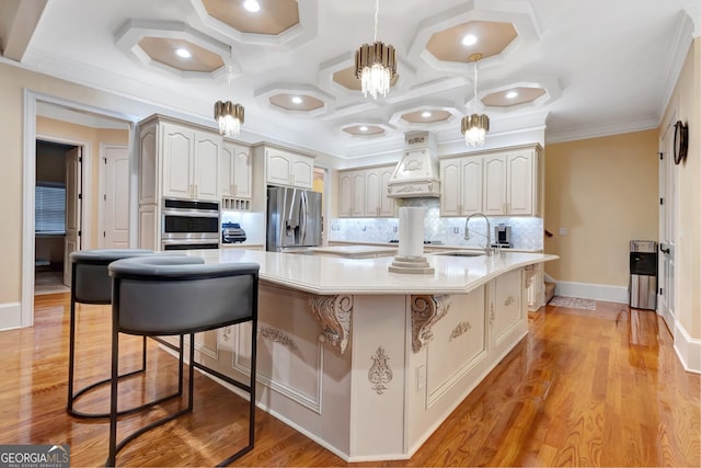 kitchen with custom exhaust hood, a kitchen bar, light hardwood / wood-style floors, appliances with stainless steel finishes, and tasteful backsplash