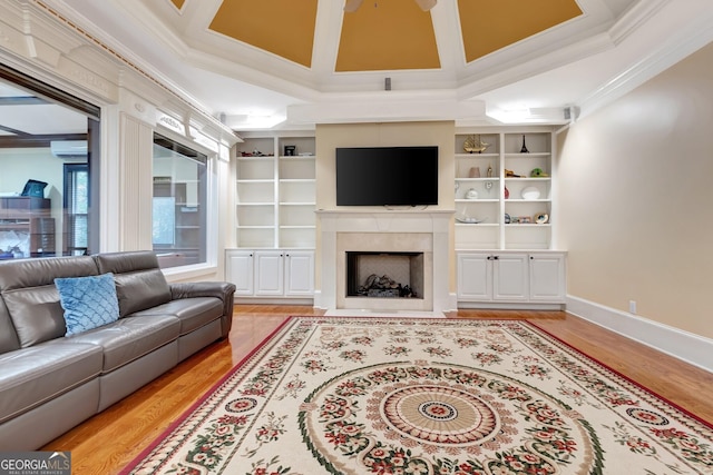 living room featuring crown molding, coffered ceiling, a wall mounted air conditioner, light wood-type flooring, and built in shelves