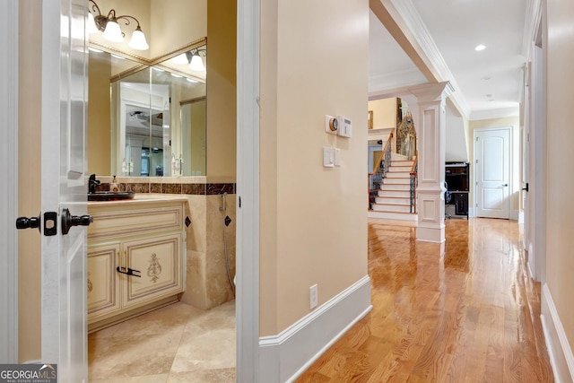 bathroom featuring hardwood / wood-style flooring, vanity, and ornamental molding