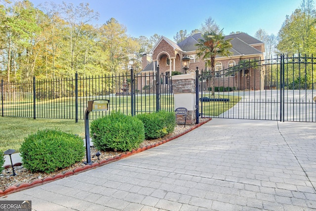 view of gate with a lawn