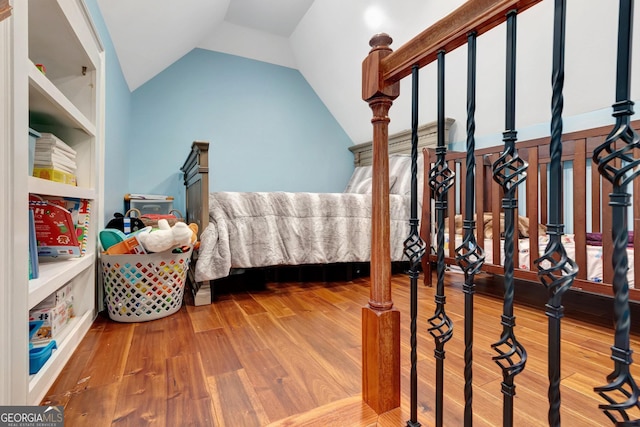 bedroom with hardwood / wood-style floors and vaulted ceiling