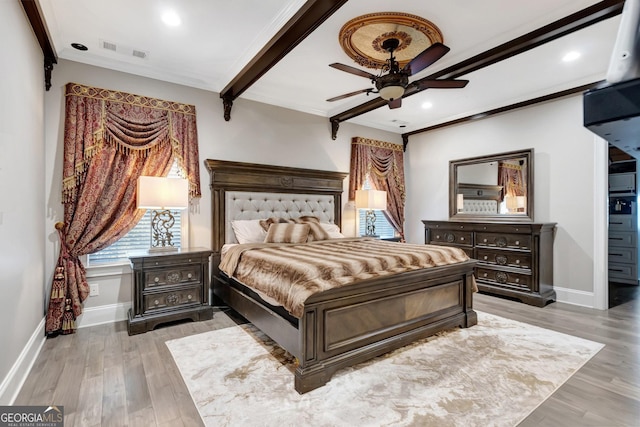 bedroom with ceiling fan, wood-type flooring, ornamental molding, and beamed ceiling