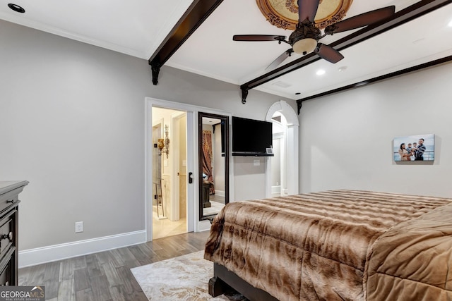 bedroom with ceiling fan, beam ceiling, dark hardwood / wood-style floors, and connected bathroom