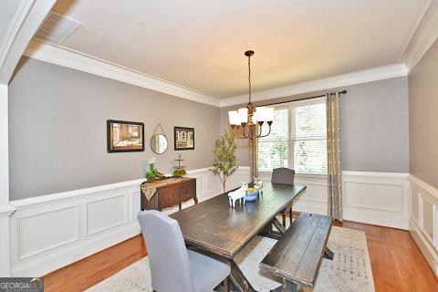 dining space featuring a notable chandelier, crown molding, and light hardwood / wood-style flooring