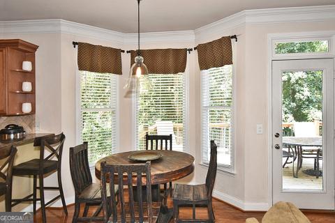 dining space with plenty of natural light, dark hardwood / wood-style floors, and crown molding