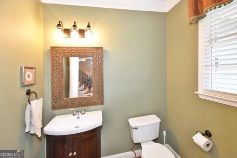 bathroom with vanity, toilet, and ornamental molding