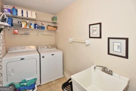 laundry area featuring light tile patterned floors and washing machine and clothes dryer