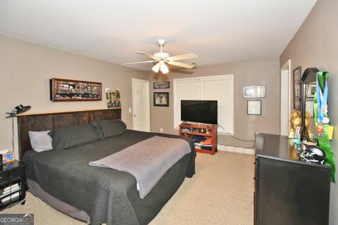 bedroom featuring light carpet and ceiling fan