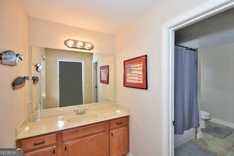 bathroom with tile patterned flooring, vanity, toilet, and curtained shower