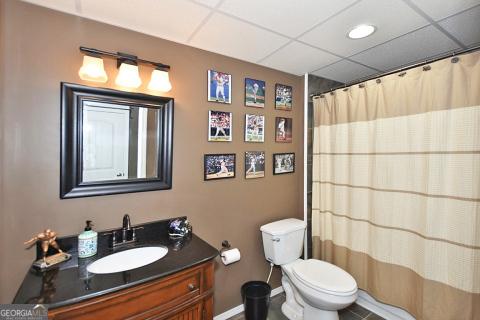 bathroom with tile patterned flooring, vanity, toilet, and a shower with shower curtain