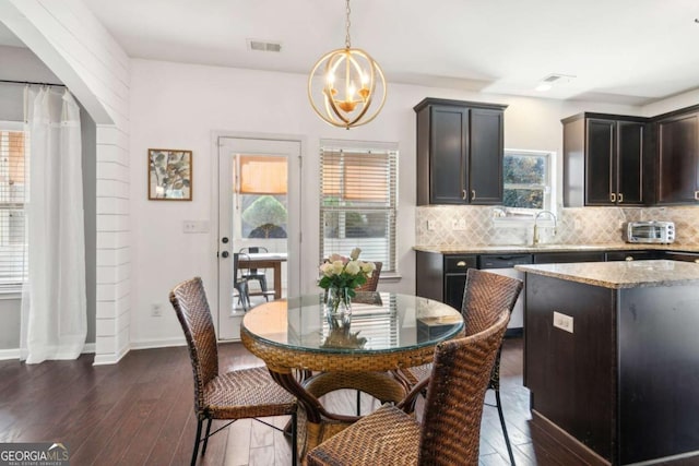 dining room with dark hardwood / wood-style floors, a notable chandelier, and sink