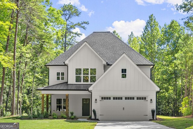 modern farmhouse featuring a front yard, a garage, and a porch