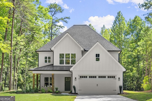 modern farmhouse with a garage, a front yard, and covered porch