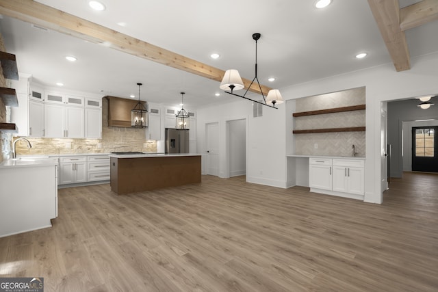 kitchen with a kitchen island, white cabinetry, open shelves, and stainless steel fridge with ice dispenser