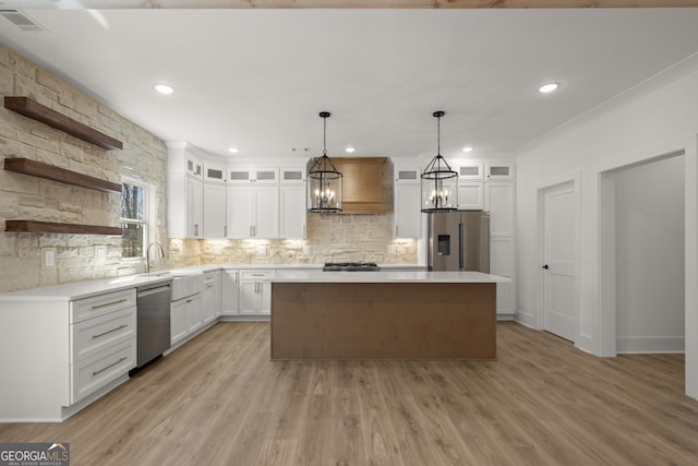 kitchen with a center island, light countertops, appliances with stainless steel finishes, glass insert cabinets, and white cabinets