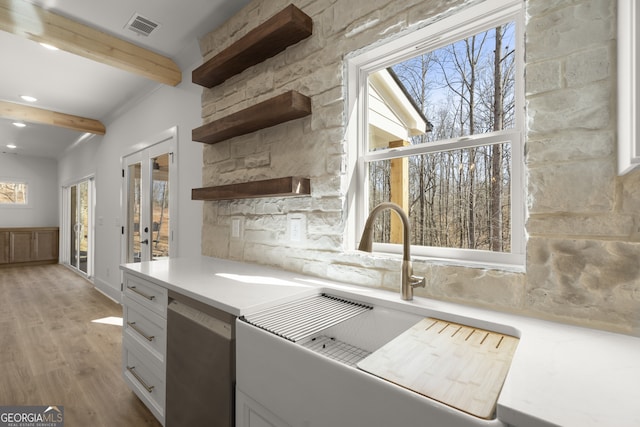 kitchen with visible vents, dishwasher, light countertops, white cabinetry, and open shelves