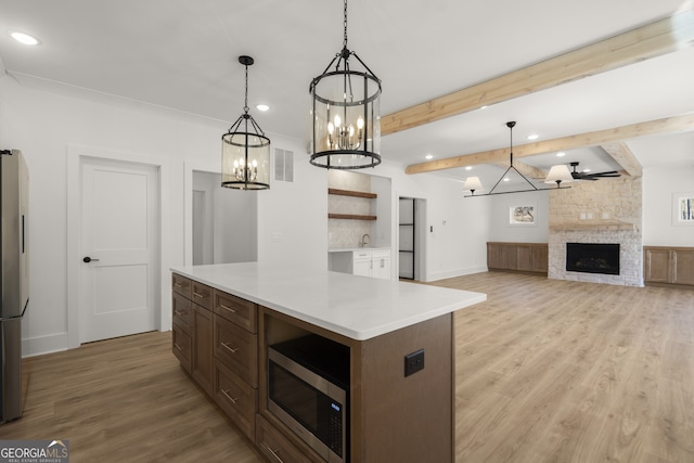 kitchen with visible vents, stainless steel appliances, light countertops, and decorative light fixtures