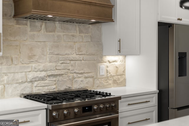 kitchen with stainless steel appliances, tasteful backsplash, light countertops, custom range hood, and white cabinetry