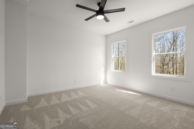 unfurnished room featuring a ceiling fan, baseboards, visible vents, and carpet flooring