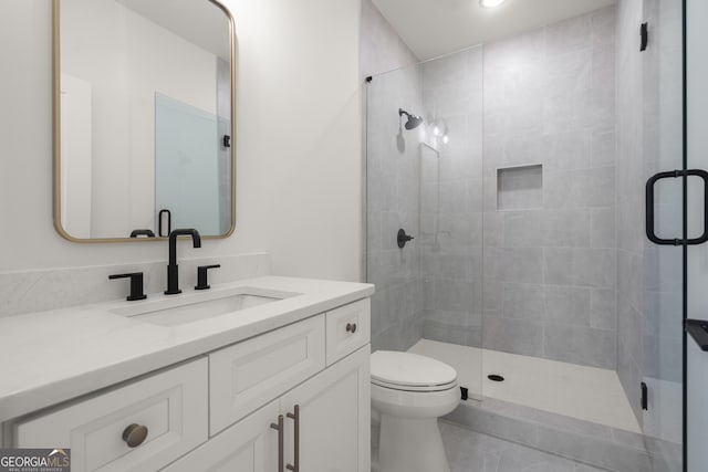 bathroom featuring a stall shower, vanity, and toilet