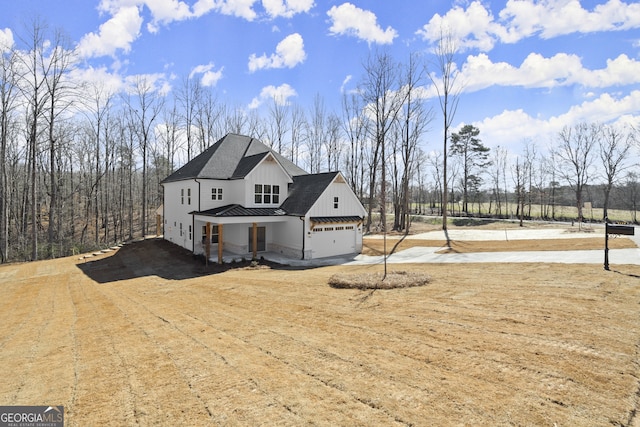 view of front of house with roof with shingles, board and batten siding, a standing seam roof, metal roof, and a garage